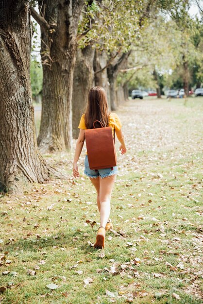 公園を歩いている女性のフルショット