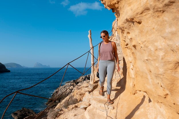 Full shot woman walking on rock