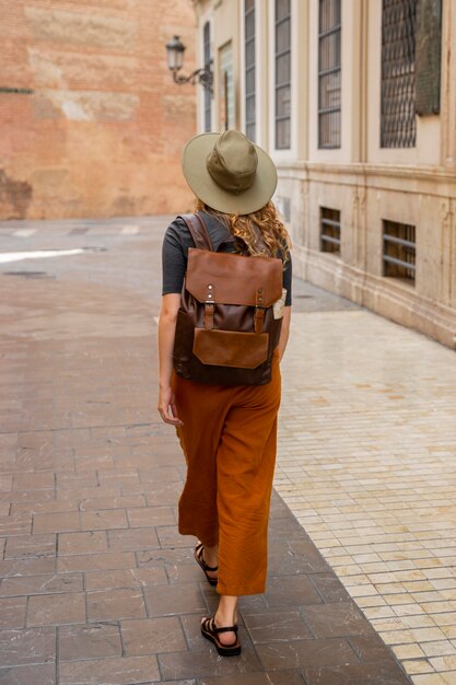 Full shot woman walking through city