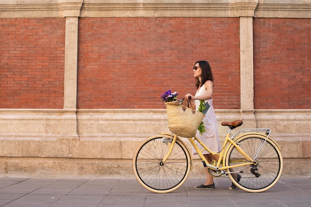 自転車で歩くフルショットの女性