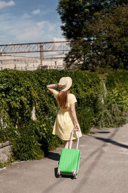 Free photo full shot woman walking with luggage