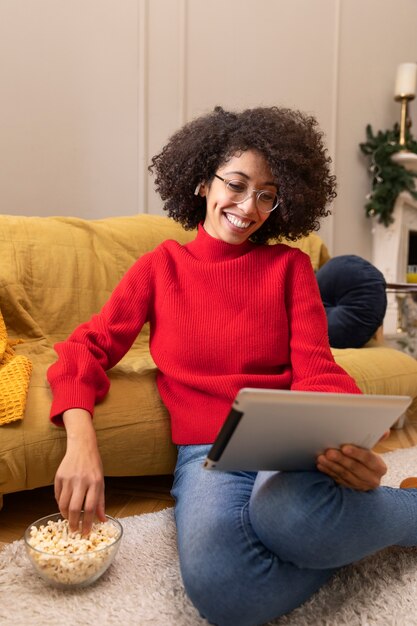 Full shot woman watching movie on tablet