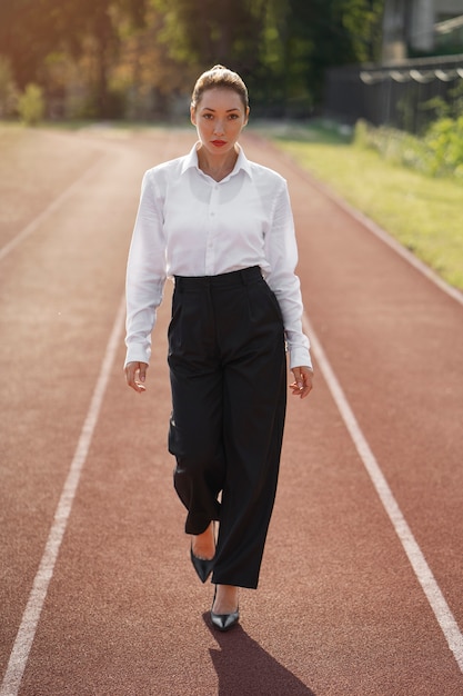 Full shot woman wearing suit on running track