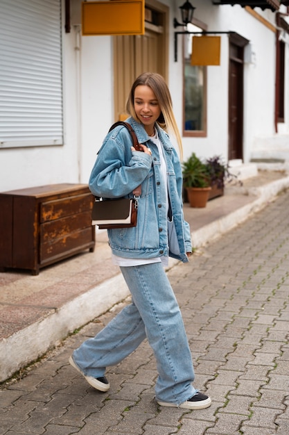 Donna a figura intera che indossa un completo in denim totale