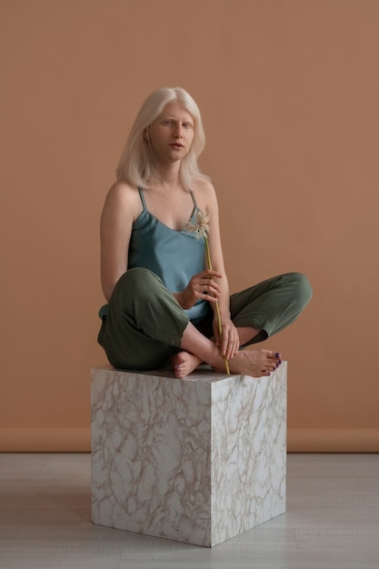 Full shot woman with albinism posing in studio
