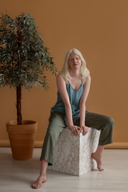 Full shot woman with albinism posing in studio