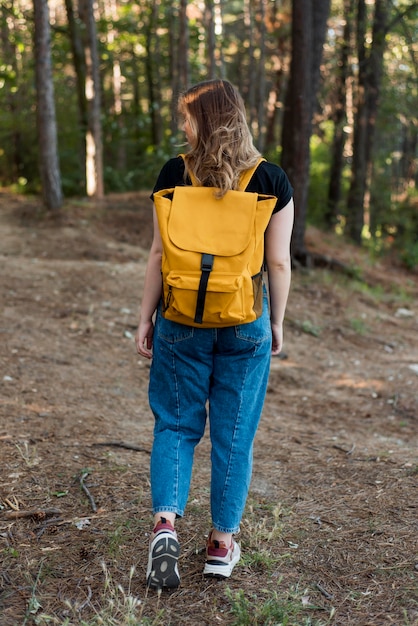 Full shot woman with backpack in woods