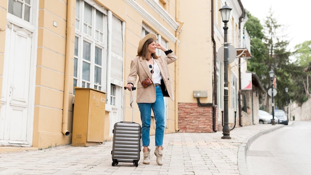 Free photo full shot woman with baggage