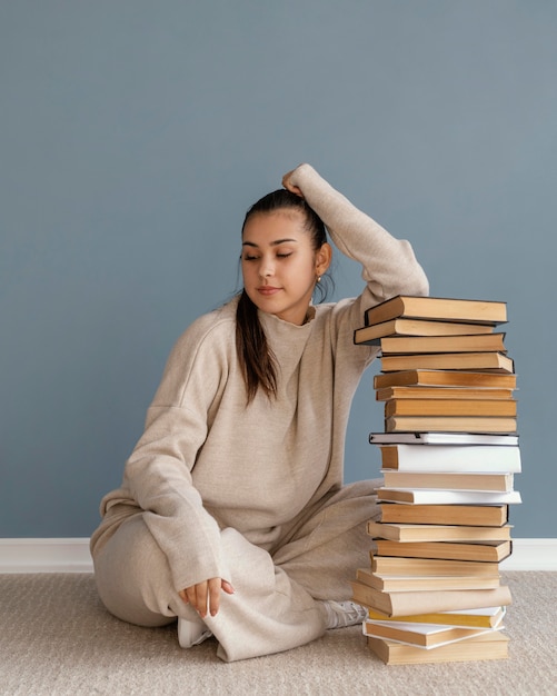 Full shot woman with books stack