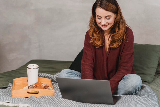 Full shot woman with breakfast in bed