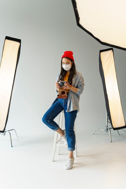 Full shot woman with camera and mask