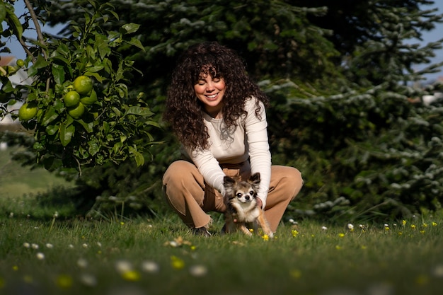 Foto gratuita donna a tutto campo con un simpatico cane chihuahua