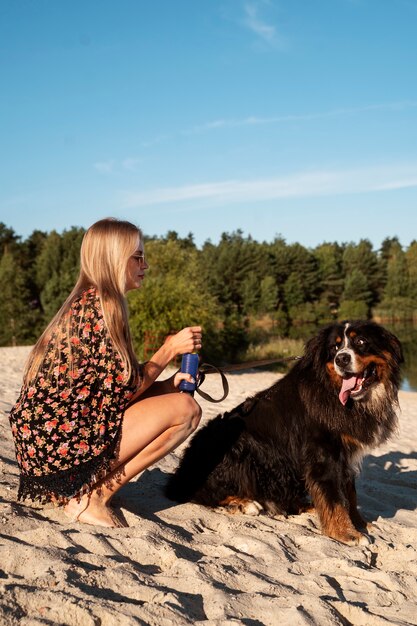 Full shot woman with cute dog on beach