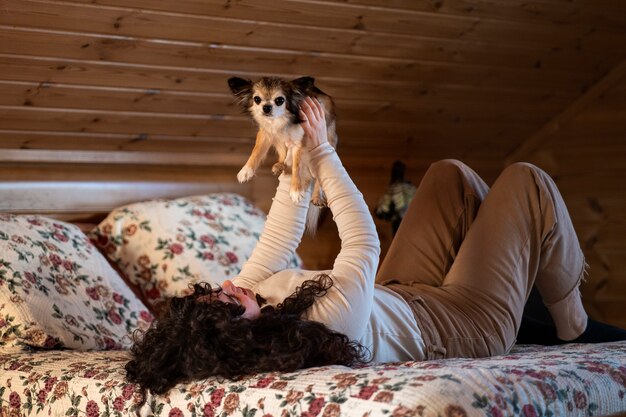 家でかわいい犬とフルショットの女性