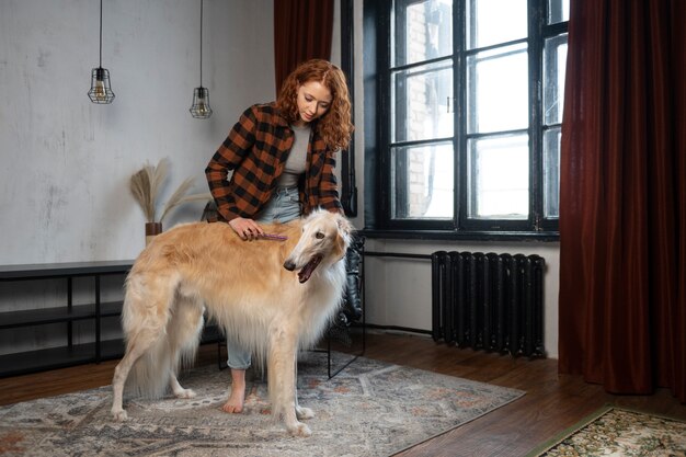 Full shot woman with cute greyhound dog