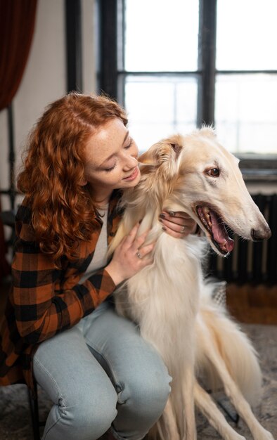 full shot woman with cute greyhound dog