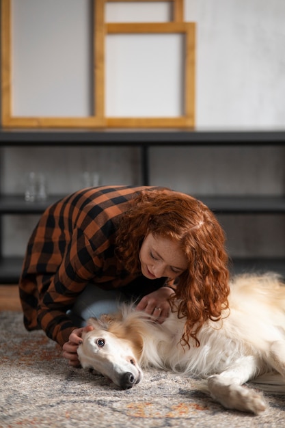 Full shot woman with cute greyhound dog