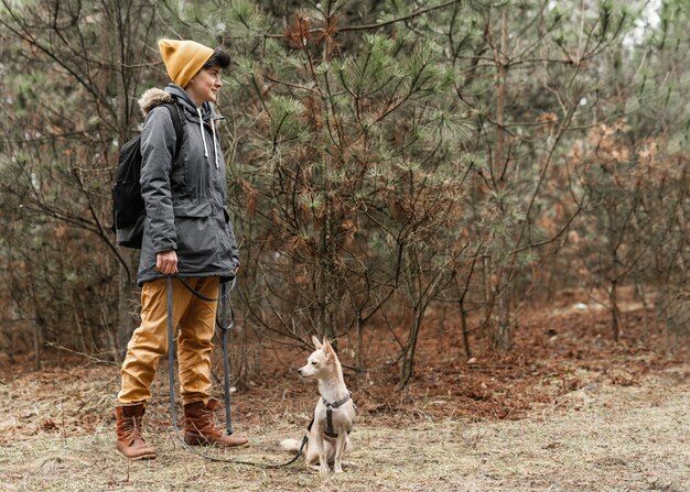 Full shot woman with dog in forest