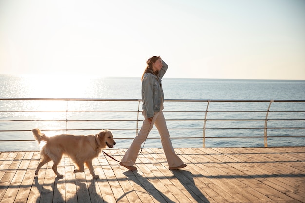 Full shot woman with dog on a jetty