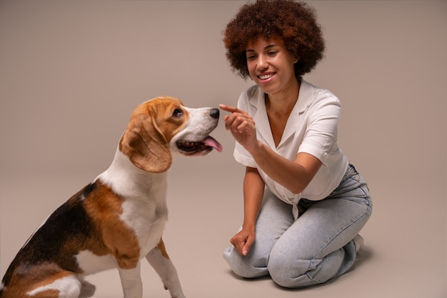 スタジオで犬を持つフルショットの女性