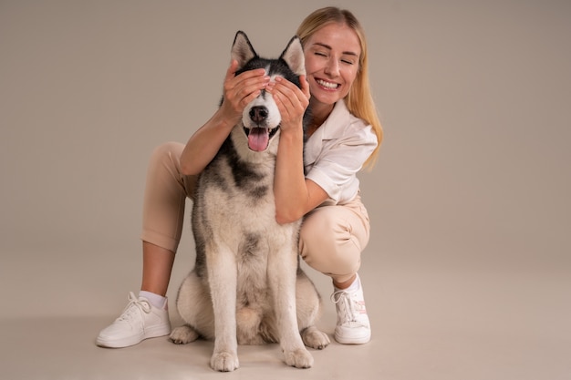 Full shot woman with dog in studio