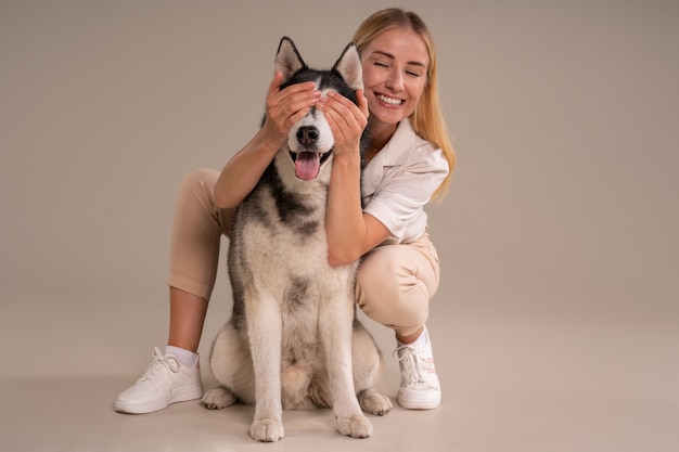 Foto gratuita donna a tutto campo con cane in studio