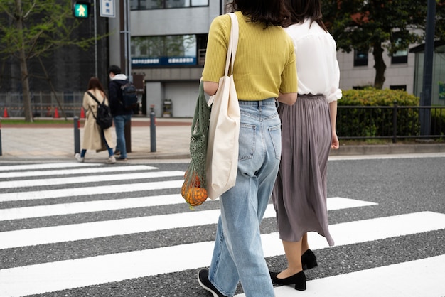 生地のバッグを持つフルショットの女性