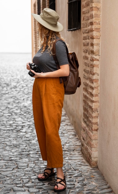 full shot woman with hat and camera