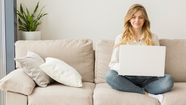 Free photo full shot woman with laptop on couch
