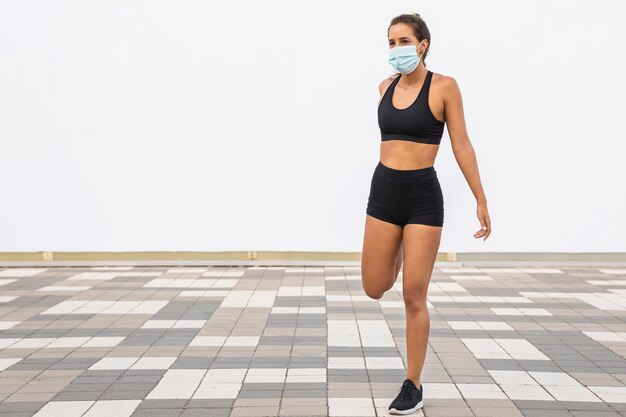 Full shot woman with mask stretching