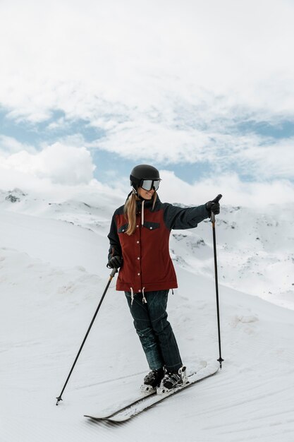 Полный снимок женщины с лыжным снаряжением