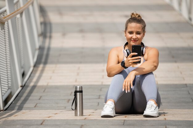 Full shot woman with smartphone