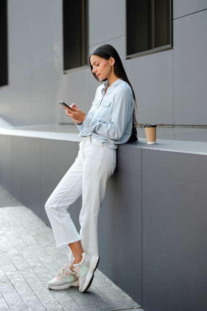 Full shot woman with smartphone