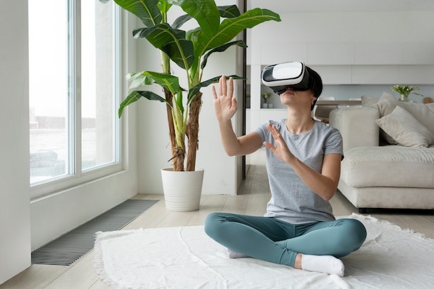 Full shot woman with vr glasses on floor