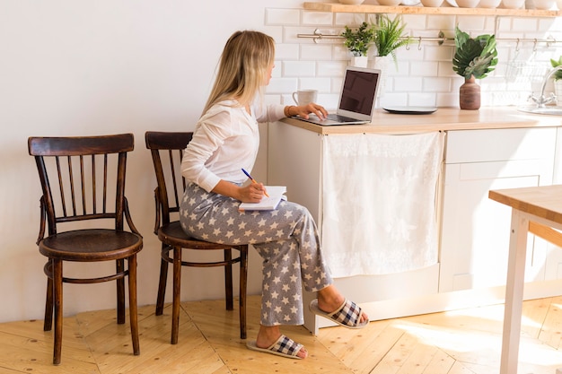 Full shot woman working on laptop