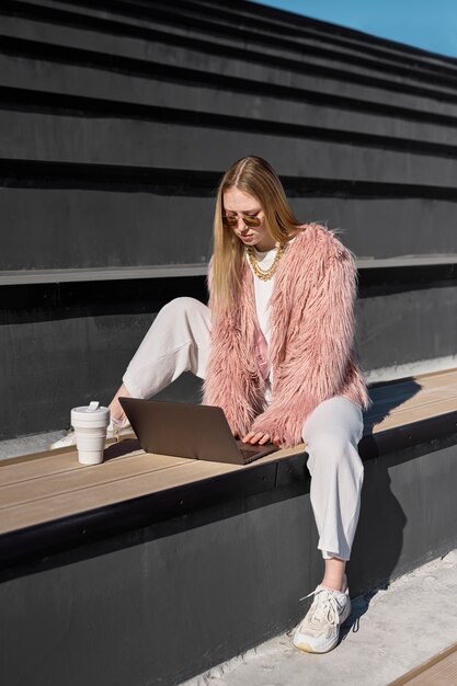 Full shot woman working on laptop