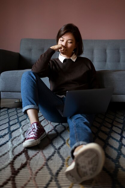 Full shot woman working on laptop