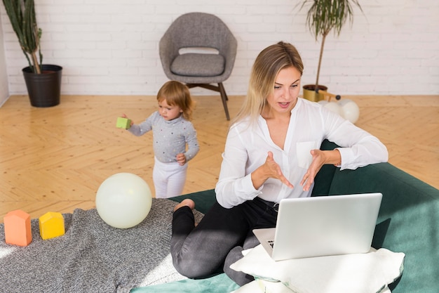 Foto gratuita donna piena del colpo che lavora con il computer portatile