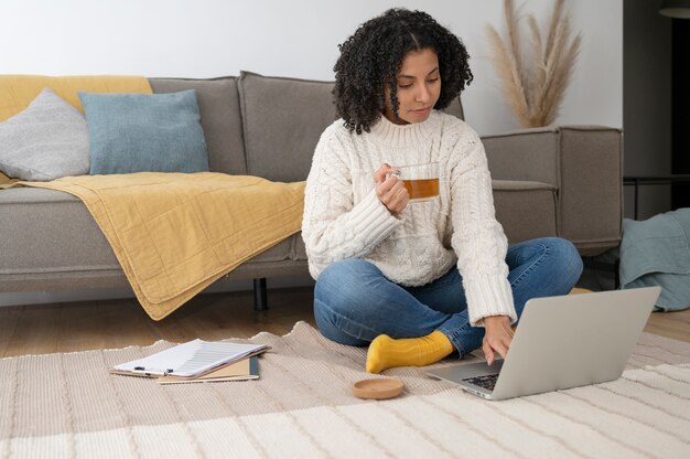 Donna del colpo pieno che lavora con il computer portatile