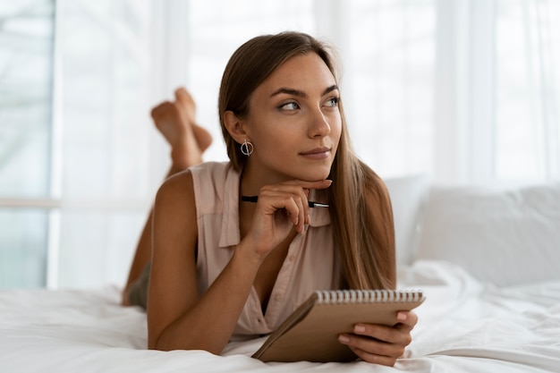 Full shot woman writing in notebook