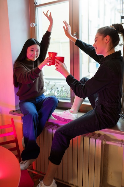 カップをチリンと鳴らすフルショットの女性