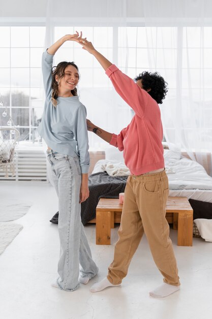 Full shot women dancing at home