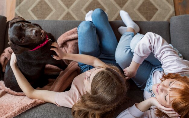 フルショットの女性とソファの上の犬