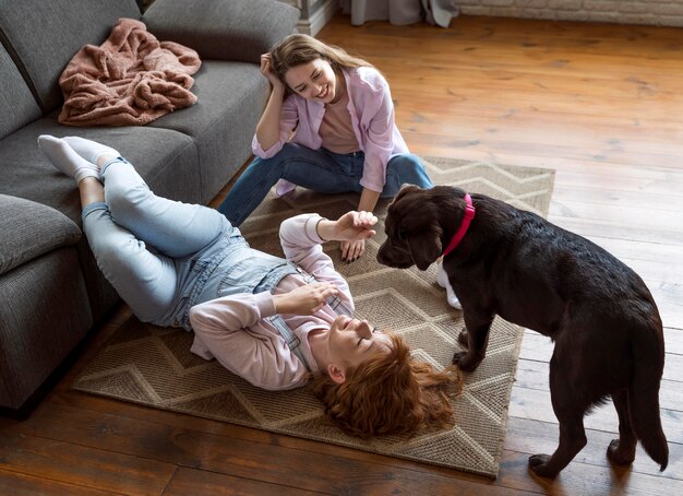 Полный снимок женщины и собаки на полу