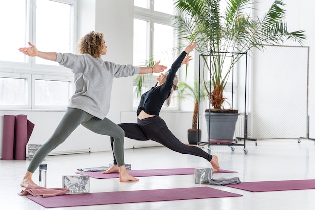 Full shot women doing yoga together