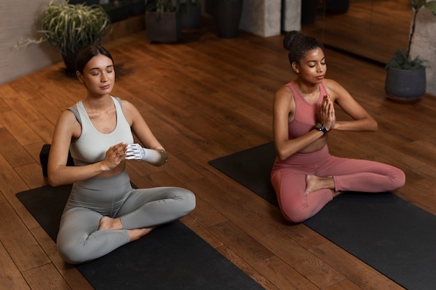 Foto gratuita donne del colpo pieno che fanno yoga insieme