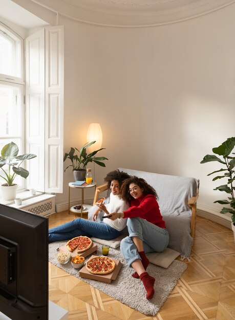 Full shot women eating pizza