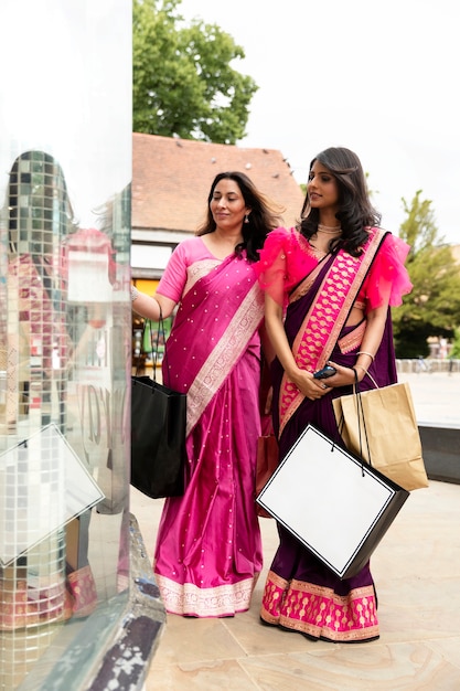 Free photo full shot women holding shopping bags