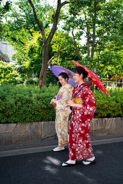 Full shot women holding wagasa umbrella