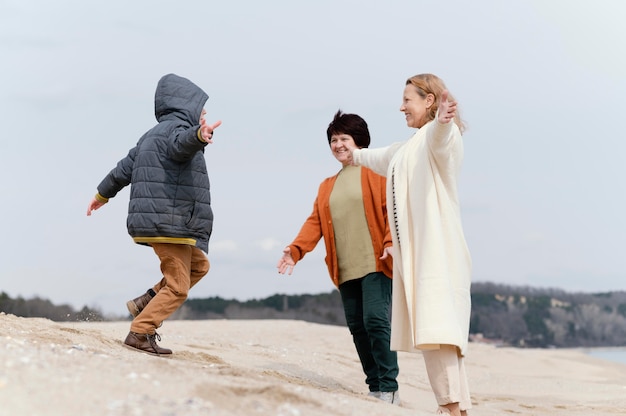 ビーチでのフルショットの女性と子供